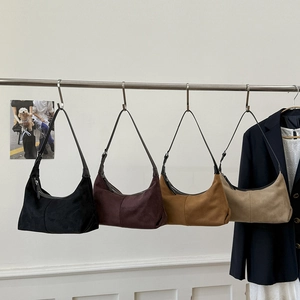 Detail view of retro suede hobo bags in four colors hanging on a metal display rack