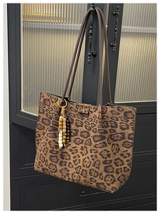Vista dettagliata della borsa tote leopardata grande con spalline marroni e nappina
