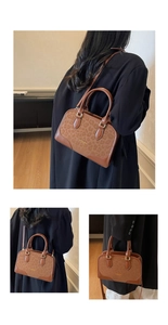 Detailed view of brown leopard print Boston bag with gold hardware and strap on model