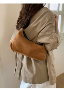 Brown faux suede crescent shoulder bag showing minimalist retro design and smooth zipper
