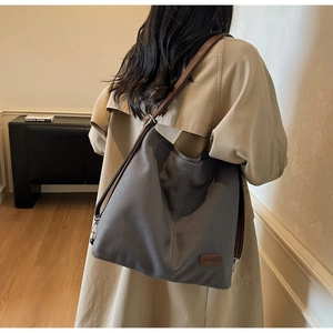 Close-up of high-density dark grey canvas tote with premium leather shoulder straps