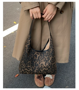Detail of leopard print tote bag styled with khaki trench coat for an autumn look