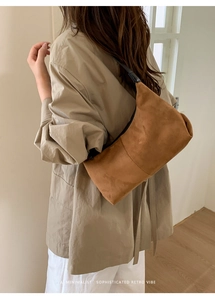 Brown suede shoulder bag shown with minimalist sophisticated retro vibe styling