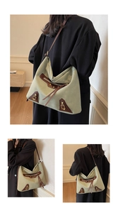 Detailed view of sage green canvas tote bag with brown leather trim and gold metal buckle