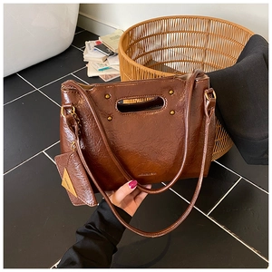 Detailed view of dark brown vintage oil wax leather bag with elegant hollow handle