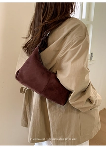 Minimalist retro burgundy suede crossbody bag worn by a model in a modern interior