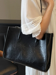 Minimalist large black tote bag with vintage matte texture and slim double handles
