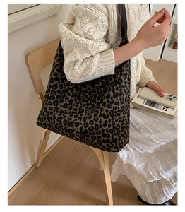 Detail shot of a large leopard print tote bag styled in a cozy lifestyle setting