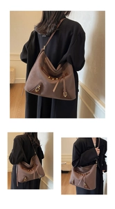 Detailed view of taupe tote bag with gold studs and fringe tassel zipper for women