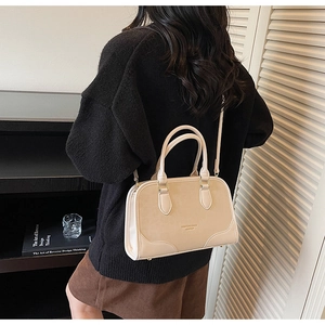 Side view of beige crossbody pillow bag with fine leather texture shown on model