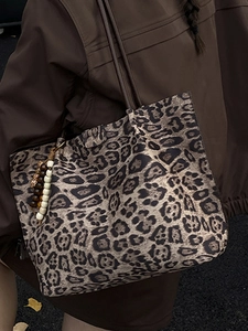 Grande borsa tote leopardata con ciondolo di perline e spalline marroni su modella