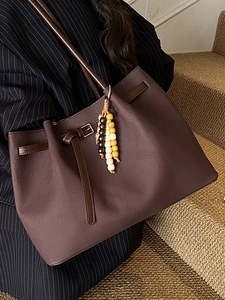 Vintage dark brown tote bag for women with tassel charm in a minimalist office style