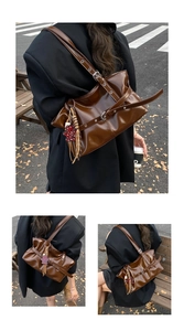 Détail du sac bandoulière en cuir marron brillant avec boucles argentées et breloque léopard
