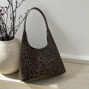 Detailed view of leopard print hobo tote bag texture on a minimalist stone display
