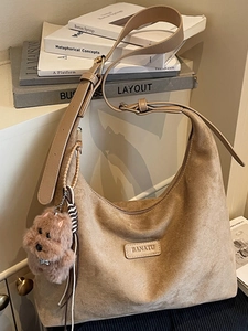 Large khaki suede hobo bag with wide shoulder strap and cute plush dog pendant charm