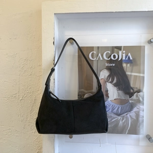 Close-up of black suede hobo bag with matte finish and silver zipper hardware details