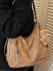 Brown soft leather hobo tote bag with front zipper and plush dog pendant for women