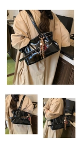 Détail du sac à bandoulière noir plissé brillant avec breloque étoile et lanières