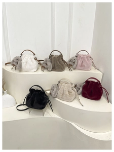 Détail de sacs seaux en peluche de six couleurs avec cordon et breloques lapin