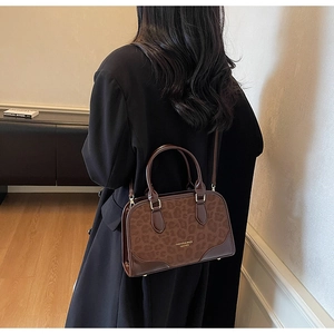 Chic Boston bag with leopard print and brown leather trim shown in a lifestyle setting