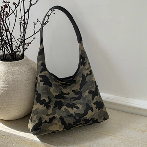 Detailed view of leopard print tote bag with camouflage pattern and black leather strap