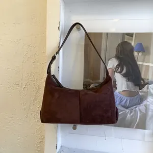 Detail view of the dark brown suede hobo bag featuring adjustable silver metal buckle strap