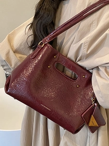 Vintage burgundy leather handbag for women featuring glossy wrinkled texture and shoulder strap