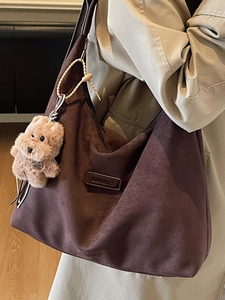 Brown suede hobo tote bag with dog charm and leather logo for autumn fashion