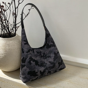 Hobo bag featuring a grey camo print on canvas texture, set on a stone surface
