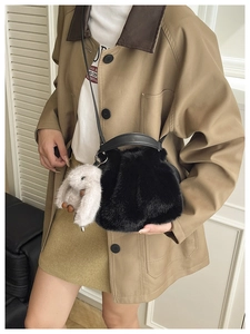 Détail d'un sac bandoulière en fausse fourrure noire avec poignées en cuir et lapin gris