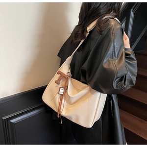 Détail du sac fourre-tout en cuir blanc cassé avec breloque à franges et bandoulière