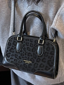 Fashionable leopard print leather handbag with twin handles and crossbody strap