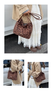Dettaglio della borsa tote leopardata con fiocco dorato e tracolla in pelle