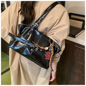 Vue détaillée du sac à bandoulière en cuir verni noir avec breloque cœur léopard rouge
