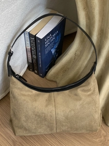 Khaki suede hobo bag with black leather shoulder strap and metallic zipper closure