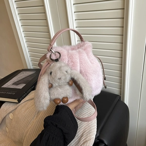 Sac seau en fausse fourrure rose avec breloque lapin en peluche et bandoulière en cuir