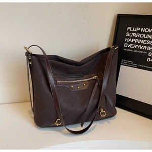 Detail view of the vintage coffee tote bag with golden studs and textured leather finish