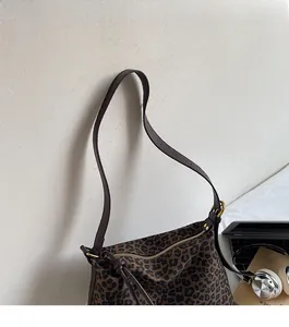 Close-up of leopard print shoulder bag with comfortable brown leather strap and gold zipper