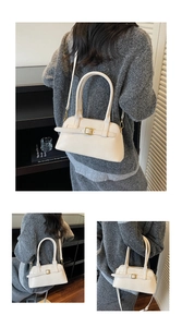 Detailed view of a white minimalist shoulder bag with buckle accent on a grey knit sweater