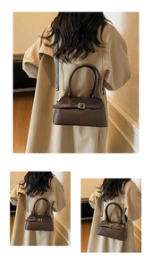 Detailed view of dark brown vintage leather shoulder bag with buckle and dual handles