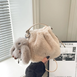 Détail du sac seau en fausse fourrure abricot avec breloque lapin et cordon de serrage doux