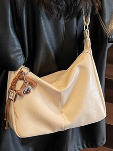 Sac fourre-tout minimaliste beige en similicuir porté à l'épaule pour un style chic