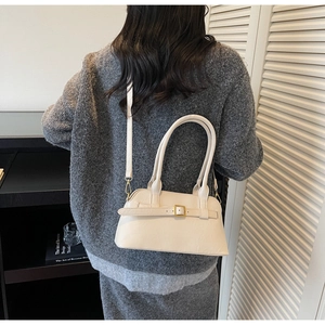 Chic off-white shoulder bag with decorative buckle shown in a lifestyle commuter outfit