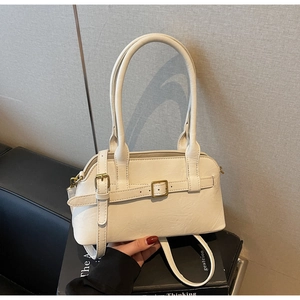 Detailed view of the cream shoulder bag with vintage gold buckle and long handles