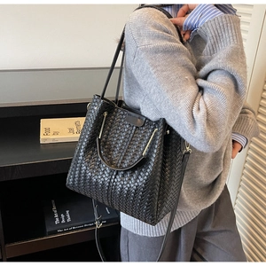 Detail of black woven bucket bag showing its premium texture and sturdy top handles