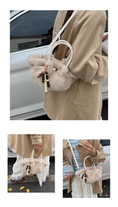 Detail of beige plush bucket bag with metal buckle and wooden bead tassel accessory