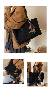 Detail of black quilted tote bag showing large capacity texture and cute doll charm