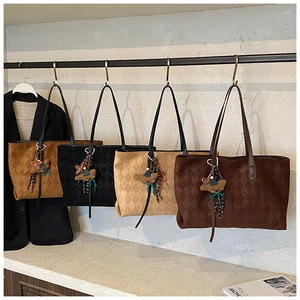 Detail view of four large tote bags featuring embossed rhombus texture and cute bear charms