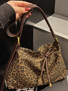 Fashionable leopard print canvas tote bag with brown leather handles and gold hardware
