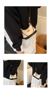 Detail view of cream and black quilted crossbody bag with gold chain and metal lock